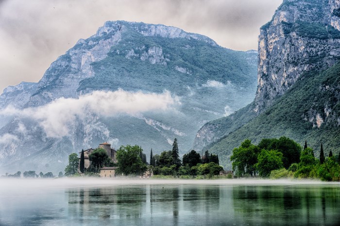 Misty lake with castle and mountains