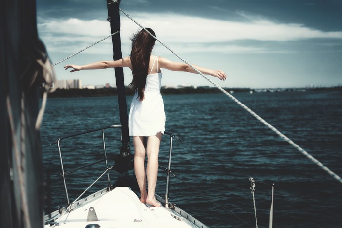 Woman in white dress on a sailboat