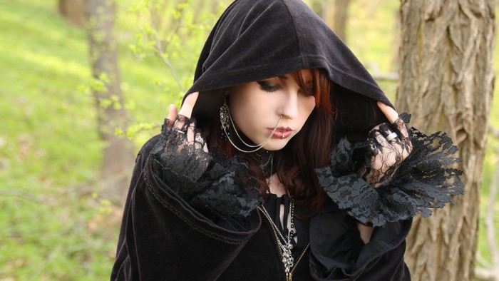 Gothic woman with piercings and black hood