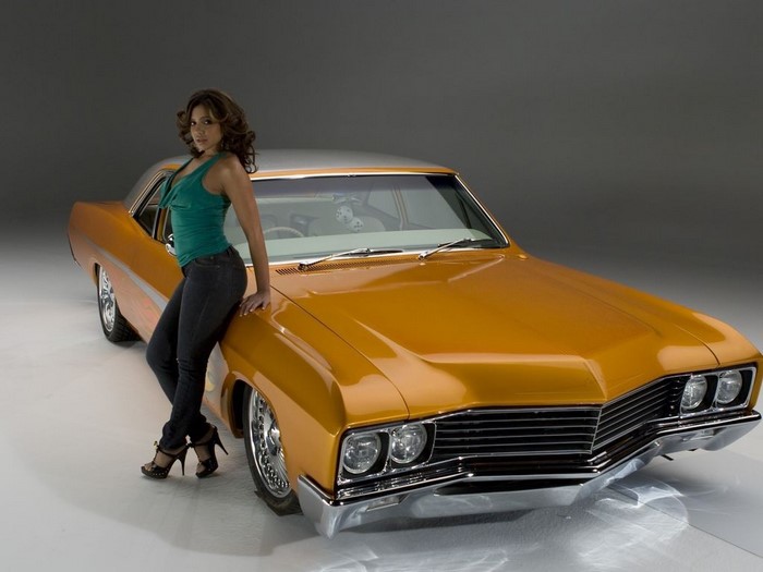 Vida Guerra posing with a classic lowrider car