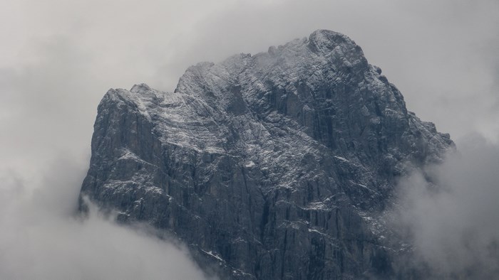 Snow-capped mountain peak emerging from fog