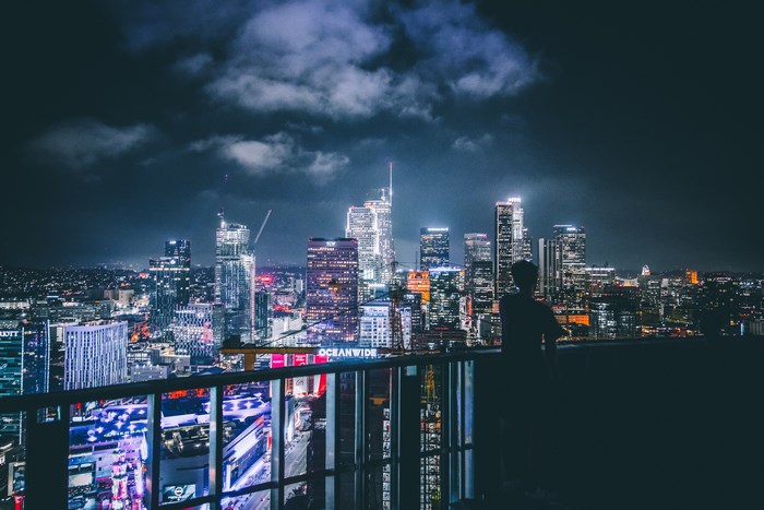 Silhouette of a person overlooking Los Angeles skyline at night