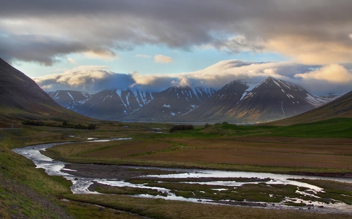 River flowing through a valley with snow-capped mountains