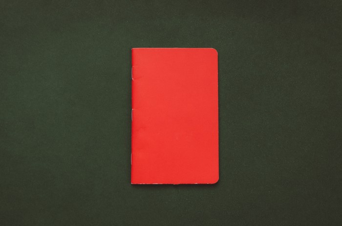 Red notebook on a dark green background