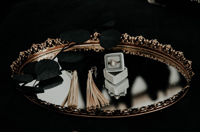 Wedding ring and earrings on a decorative tray
