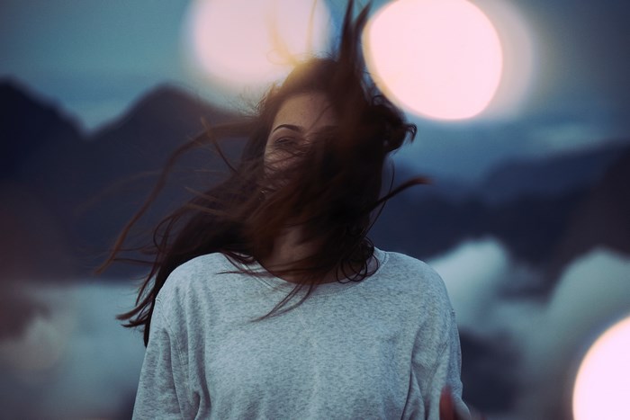 Woman with hair blowing in the wind at dusk