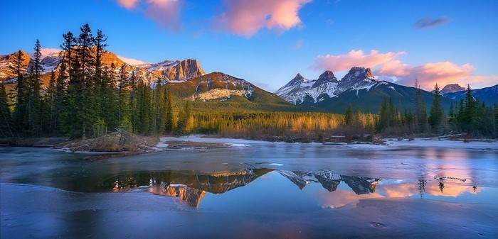 Sunrise over Three Sisters mountains and frozen lake
