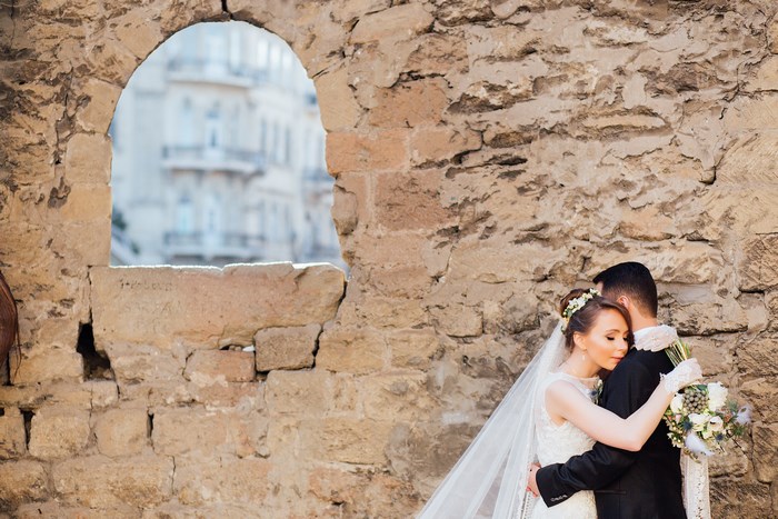 Bride and groom embracing near stone ruins