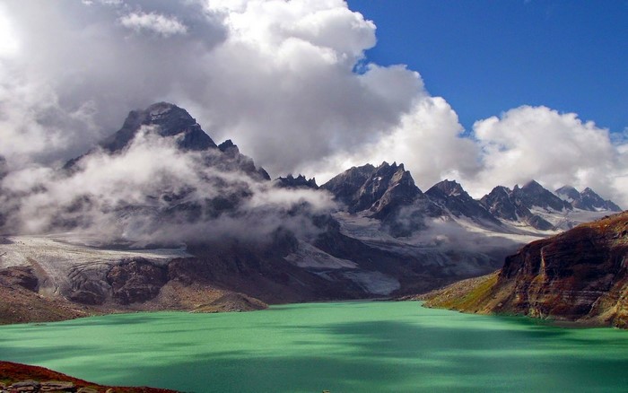 Green lake and mountains with clouds in Pakistan