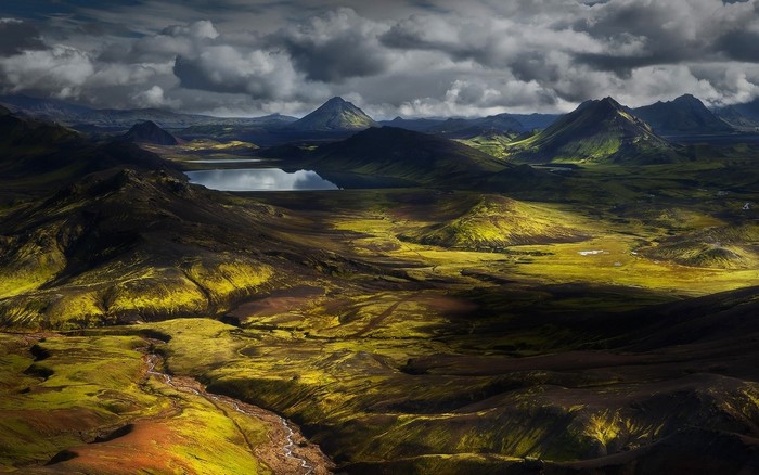 Dramatic Icelandic landscape with mountains, lake, and clouds