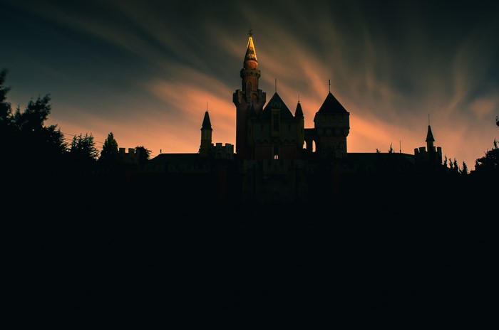 Silhouetted Castle Tower at Sunset with Clouds