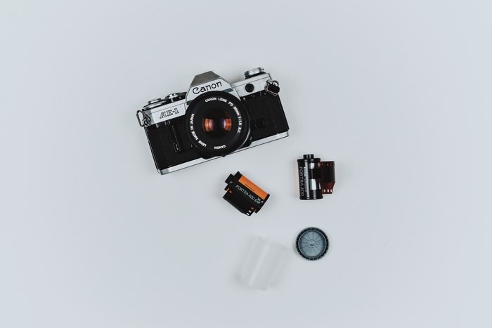 Canon AE-1 camera with film rolls and accessories