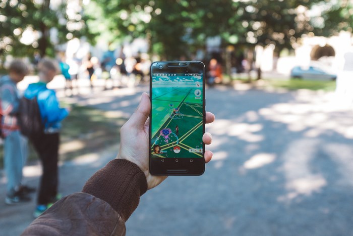 Person holding a phone playing Pokemon Go