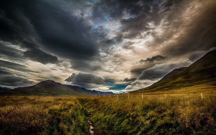 Dramatic Sky Over Icelandic Landscape with Fence