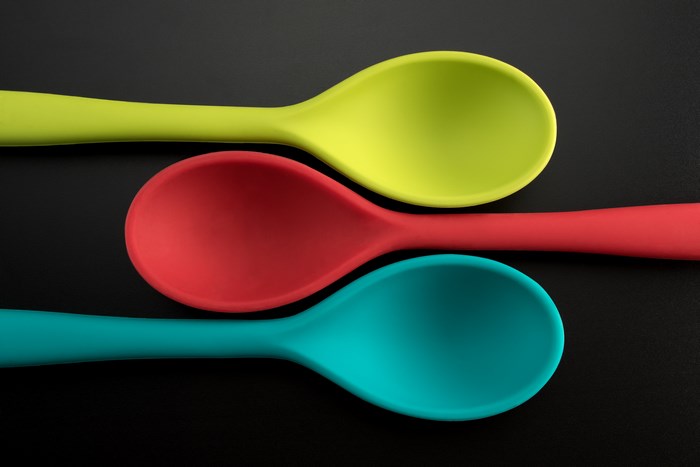 Three colorful silicone spoons on a black background