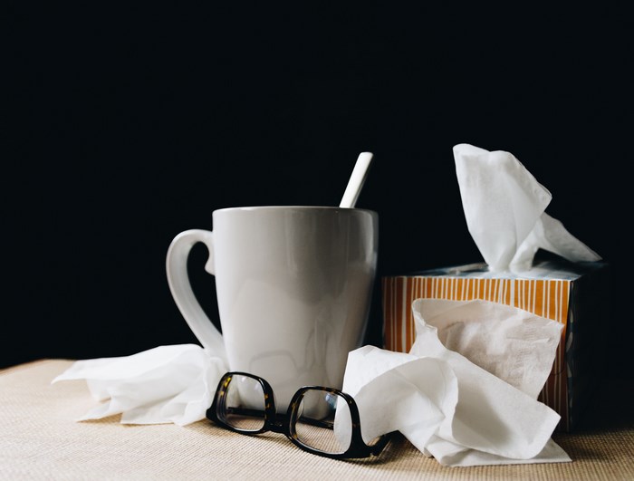 White mug with spoon, glasses, and tissues
