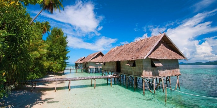 Tropical overwater bungalows on stilts in clear turquoise water