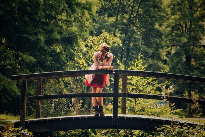 Woman resting on a wooden bridge in a forest