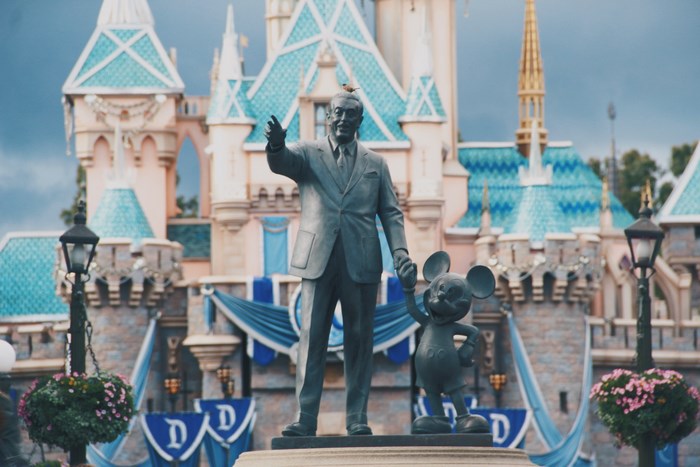 Walt Disney and Mickey Mouse statue in front of Disneyland castle
