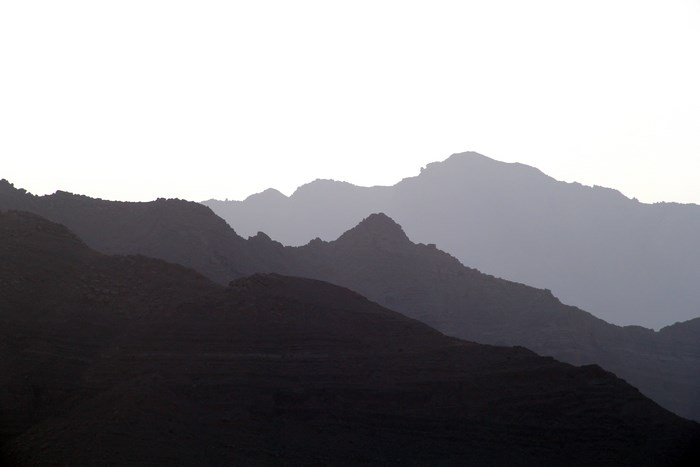 Silhouetted mountain range against a bright sky