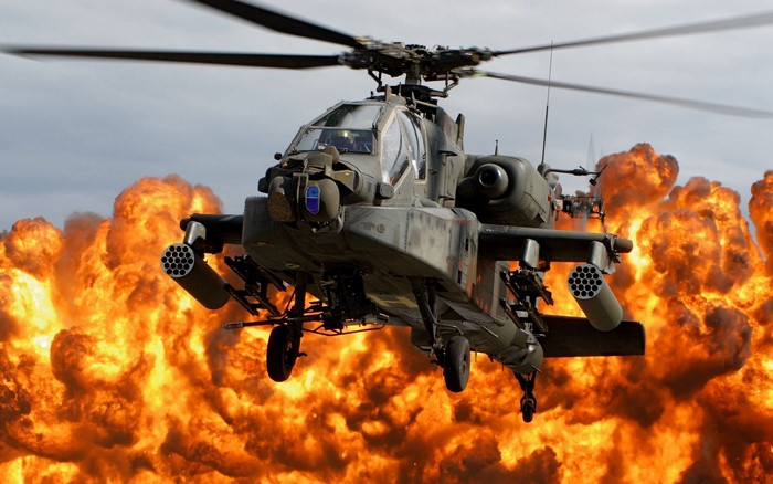AH-64 Apache helicopter in front of an explosion