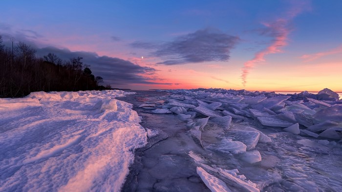Frozen lake shore at sunset with colorful sky