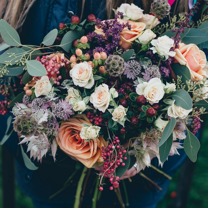 Floral bouquet with roses, berries, and eucalyptus leaves