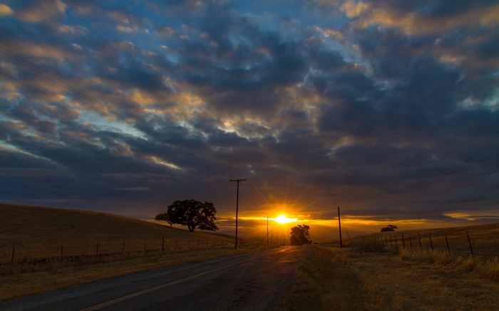 Sunset over a rural road with power lines