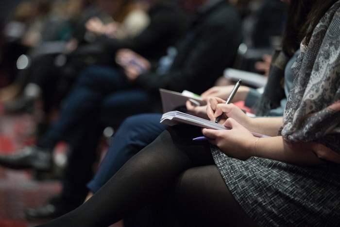 People taking notes in a meeting or class