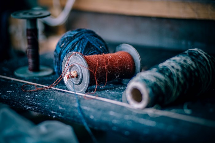 Spools of thread and yarn on a dark surface