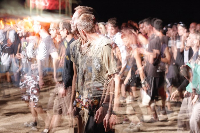Crowd dancing at an outdoor music festival at night