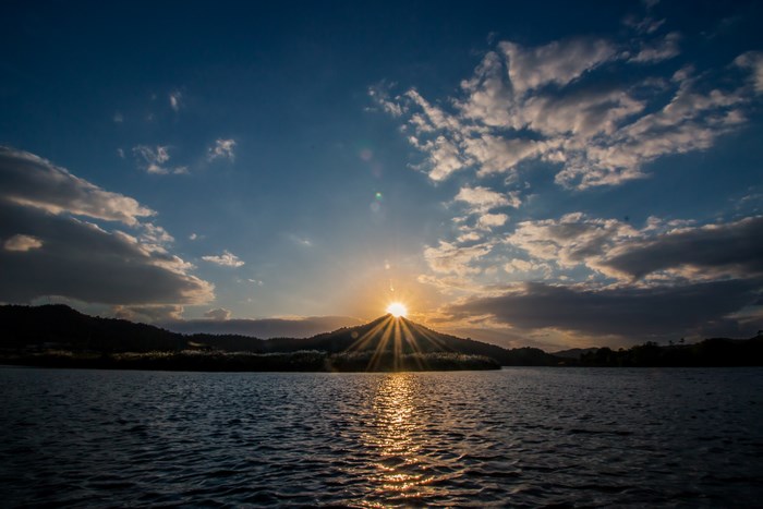 Sunset over a lake with mountains and clouds