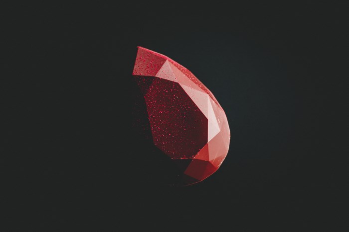 Red faceted chocolate on a dark background
