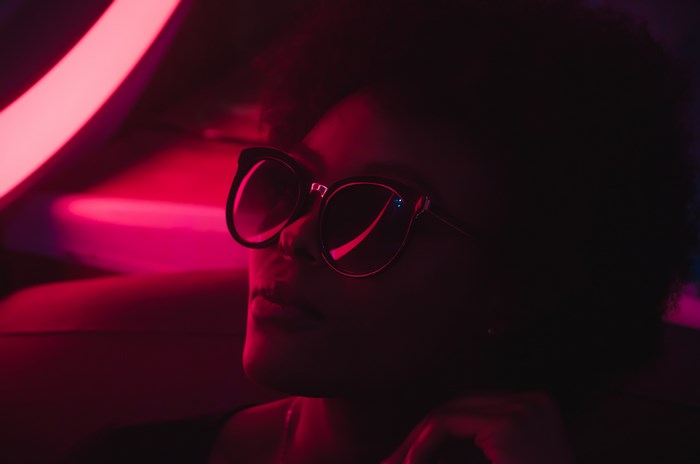 Woman wearing glasses in red neon light