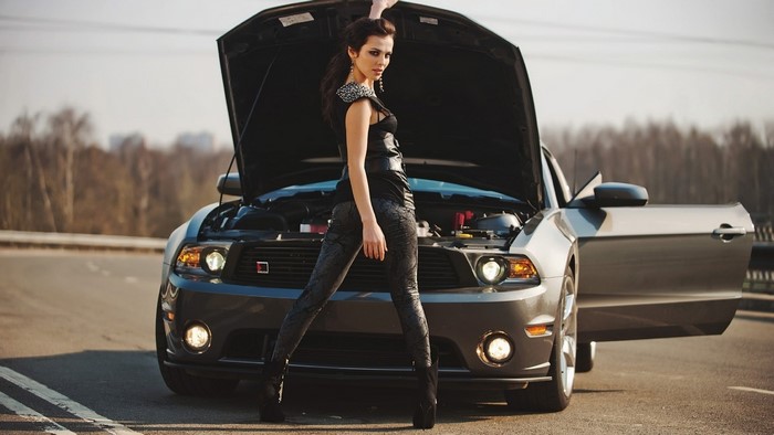 Woman posing with Ford Mustang with hood open