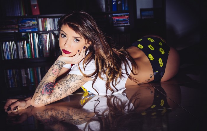 Woman with tattoos wearing shorts and white top