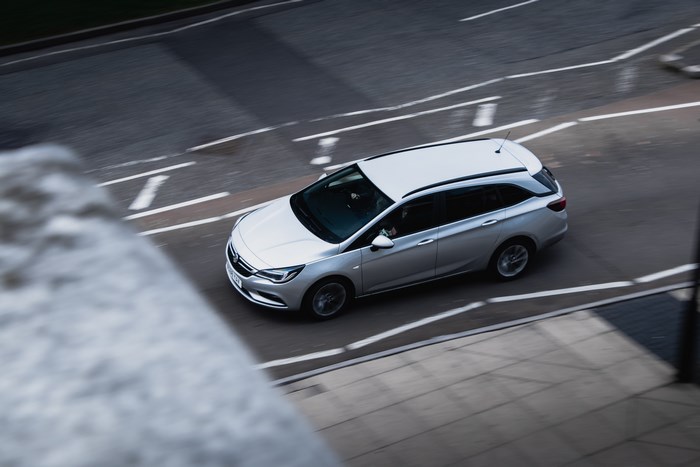 Silver station wagon driving on a city road