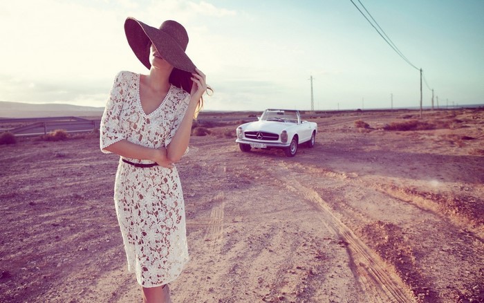 Woman in lace dress and hat with vintage Mercedes-Benz