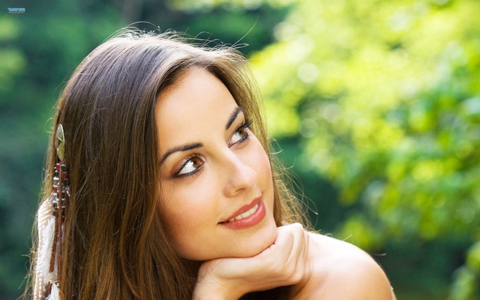 Woman with feather hair accessory outdoors