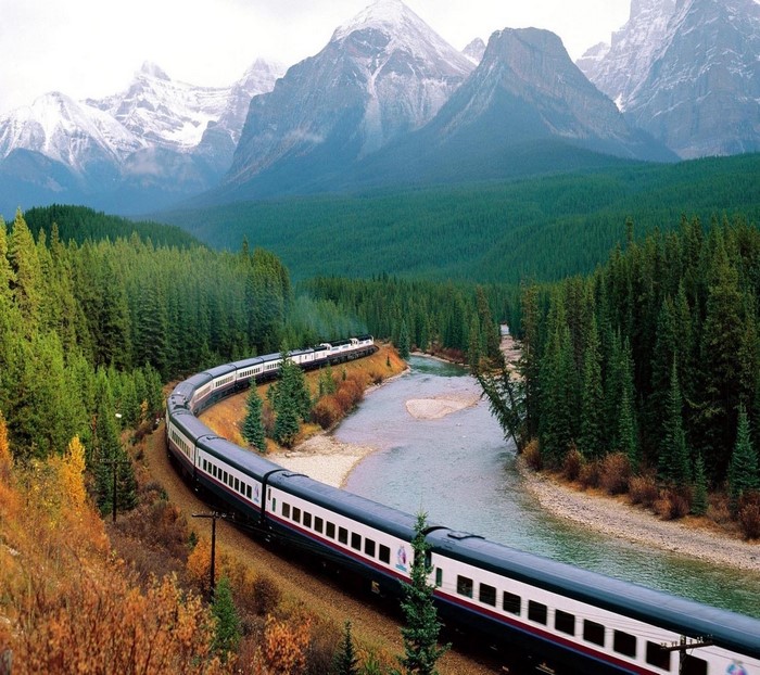 Train traveling through a mountain landscape with a river
