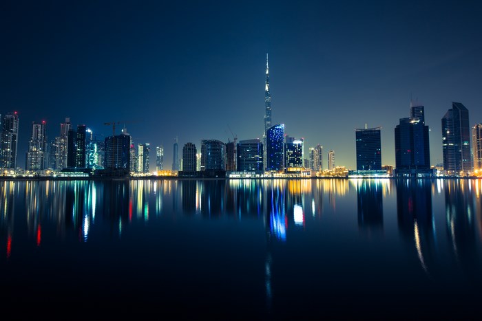 Dubai skyline at night with reflections on the water