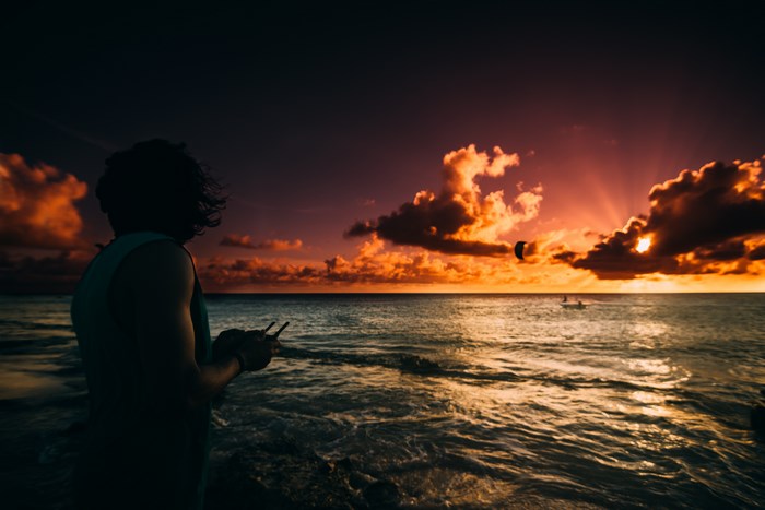 Person holding drone controller at sunset on beach