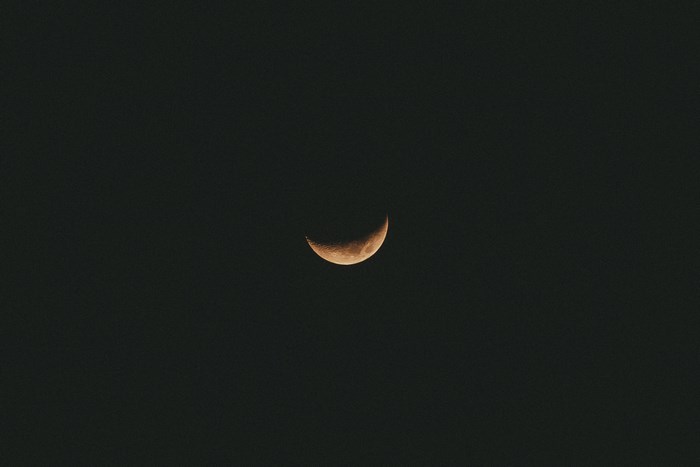 Waxing crescent moon in dark sky