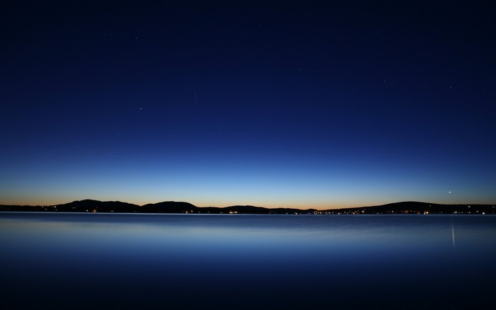 Night sky over a calm lake at dusk