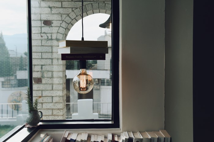 Books and lightbulb hanging in a window