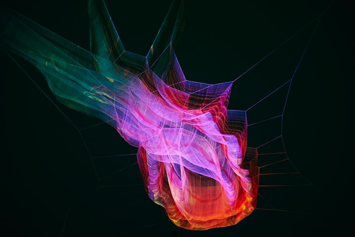 Colorful light installation suspended in darkness