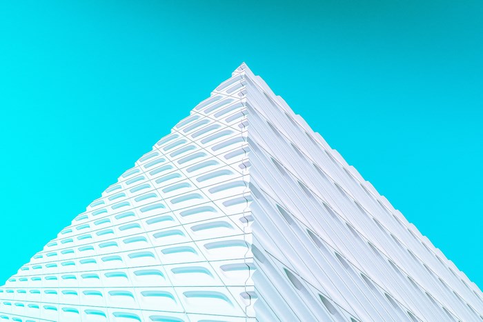 Modern white building against a bright teal sky