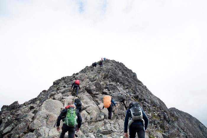 Group of hikers ascending a rocky mountain peak