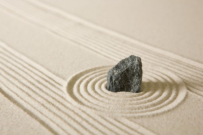 Zen garden with raked sand and a single stone