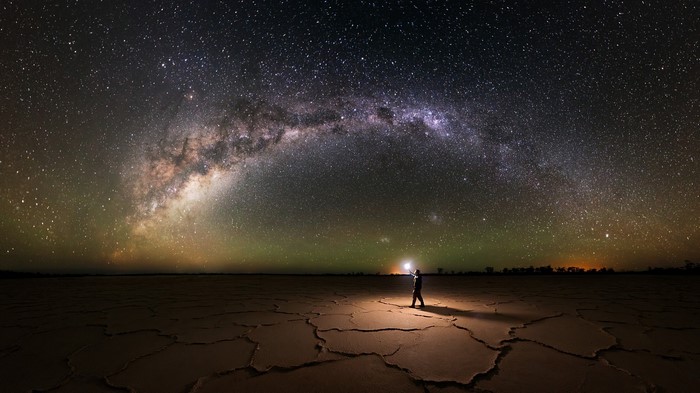 Man with lantern under Milky Way in Australia